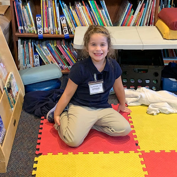 girl student sitting on floor mat