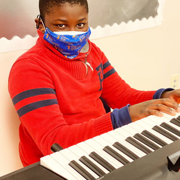 boy student playing piano