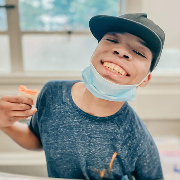 boy student smiling holding food