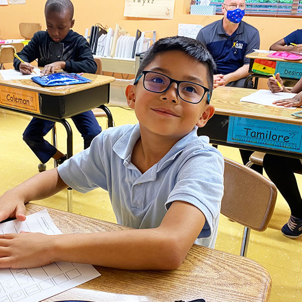 boy student at desk smiling