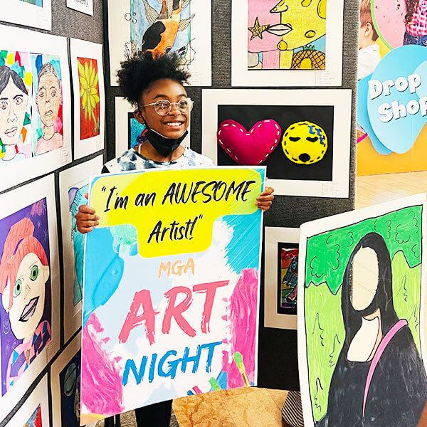 student artist holding sign for Art Night